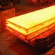 A worker tags a giant block of heated steel at the rolling mill at the ThyssenKrupp steelworks on January 13, 2010 in Duisburg, Germany.